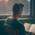 Persona in ascolto musicale accanto a una finestra, atmosfera introspettiva e stati emotivi